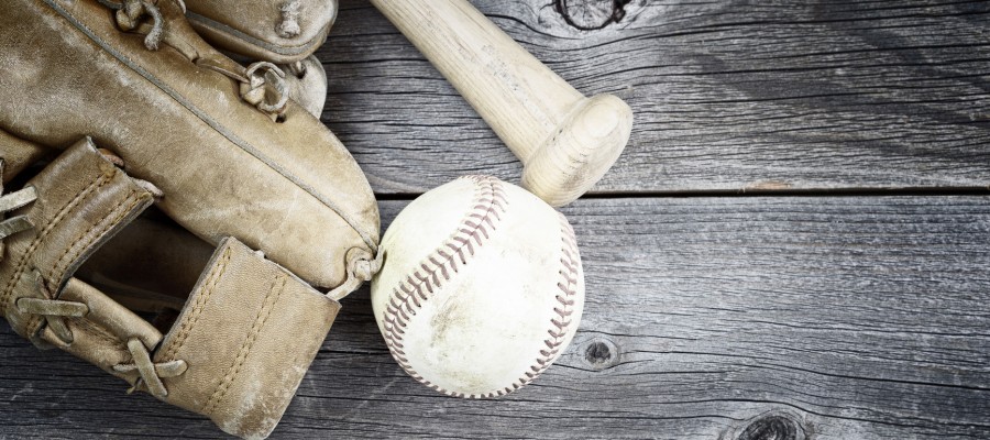 Vintage concept of  old worn glove, bat and used baseball on rustic wood
